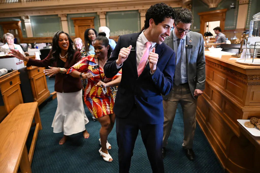Manny Rutinel, center, and other Colorado representatives dance on the state House floor in 2024