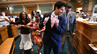 Manny Rutinel, center, and other Colorado representatives dance on the state House floor in 2024