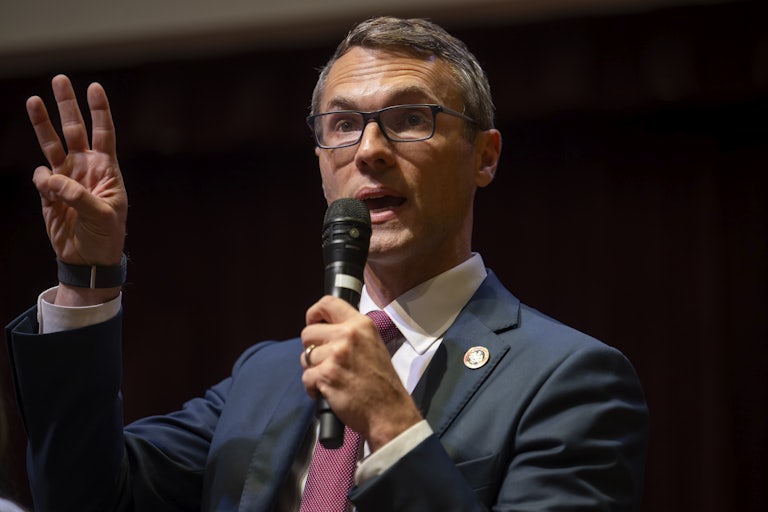 Representative-elect James Walkinshaw holds up three fingers while speaking into a microphone