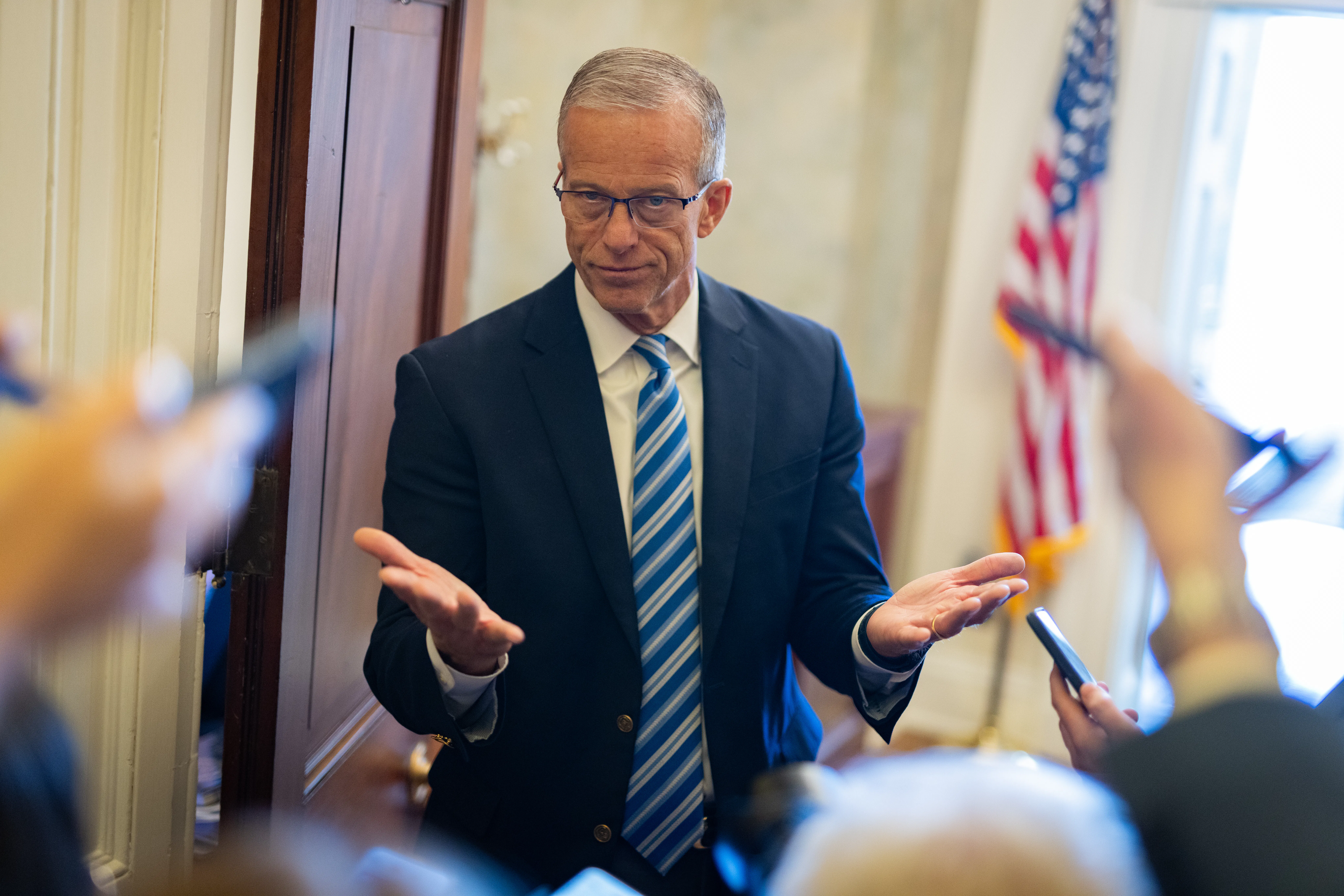 Senator John Thune makes a shrugging motion to reporters in the Capitol