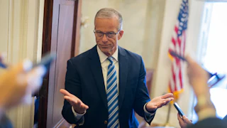 Senator John Thune makes a shrugging motion to reporters in the Capitol