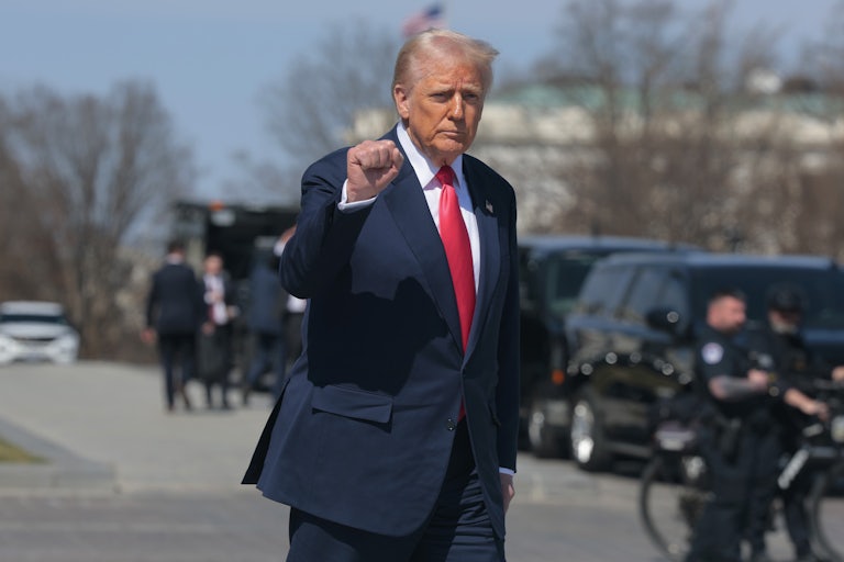 Donald Trump holds up his fist while walking outside the Capitol