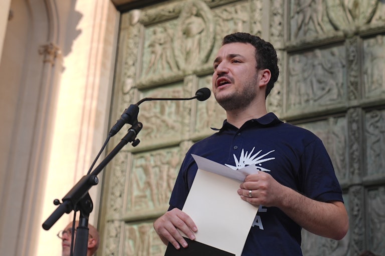 Activist Mahmoud Khalil speaks into a microphone during an event
