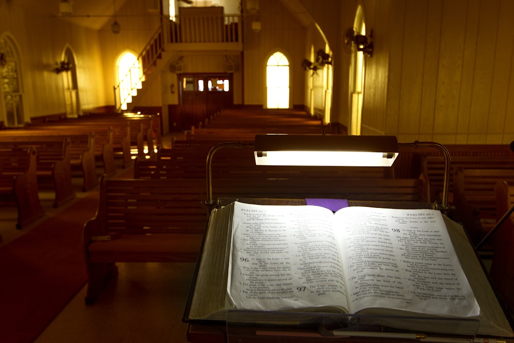 Evening light filters through colored windows at United Evangelical Lutheran Church in Swiss Alp, Texas.