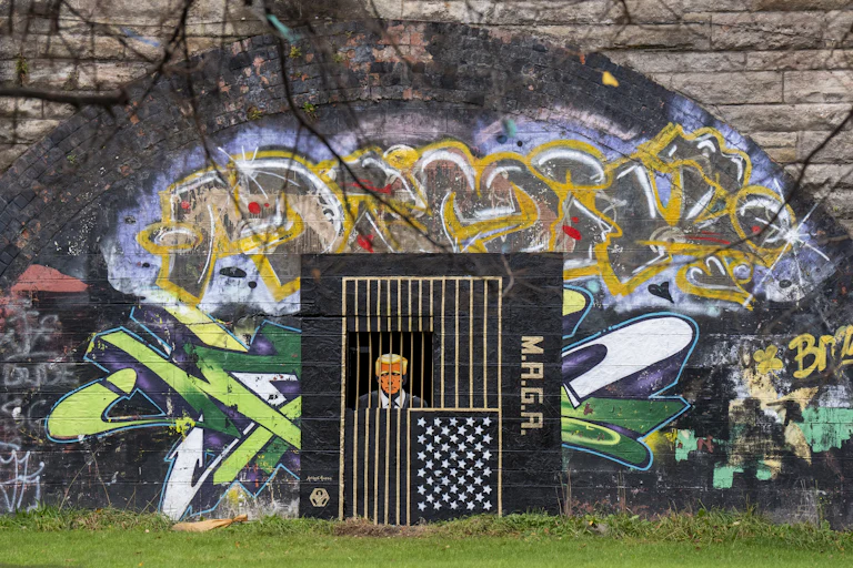 A piece of street art, by artist Ashley Rawson, depicting President Donald Trump behind bars