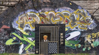 A piece of street art, by artist Ashley Rawson, depicting President Donald Trump behind bars