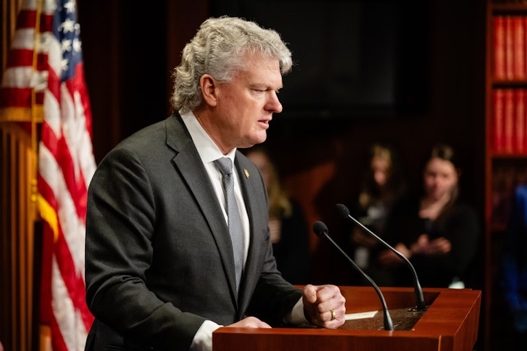 Representative Mike Collins speaks at a podium during a press conference
