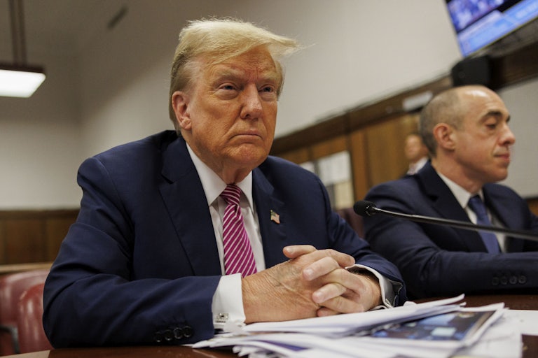 Donald Trump sits with his hands folded in front of him