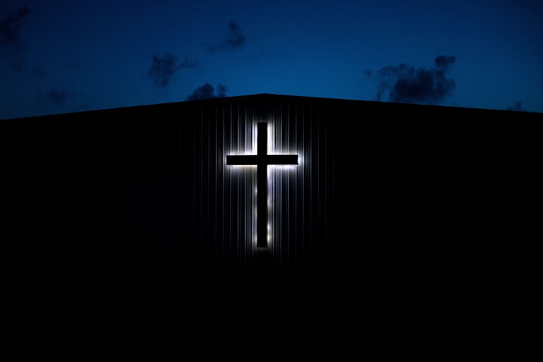 An illuminated cross on a church 