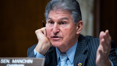Joe Manchin gesticulates while speaking.
