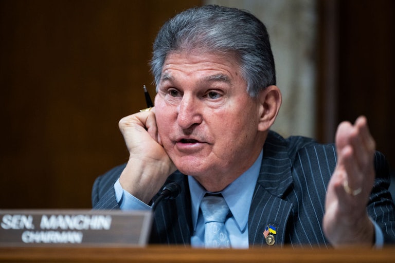 Joe Manchin gesticulates while speaking.