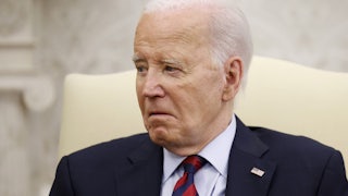Joe Biden sits in a cream chair and looks very old.