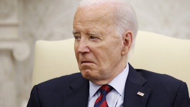 Joe Biden sits in a cream chair and looks very old.