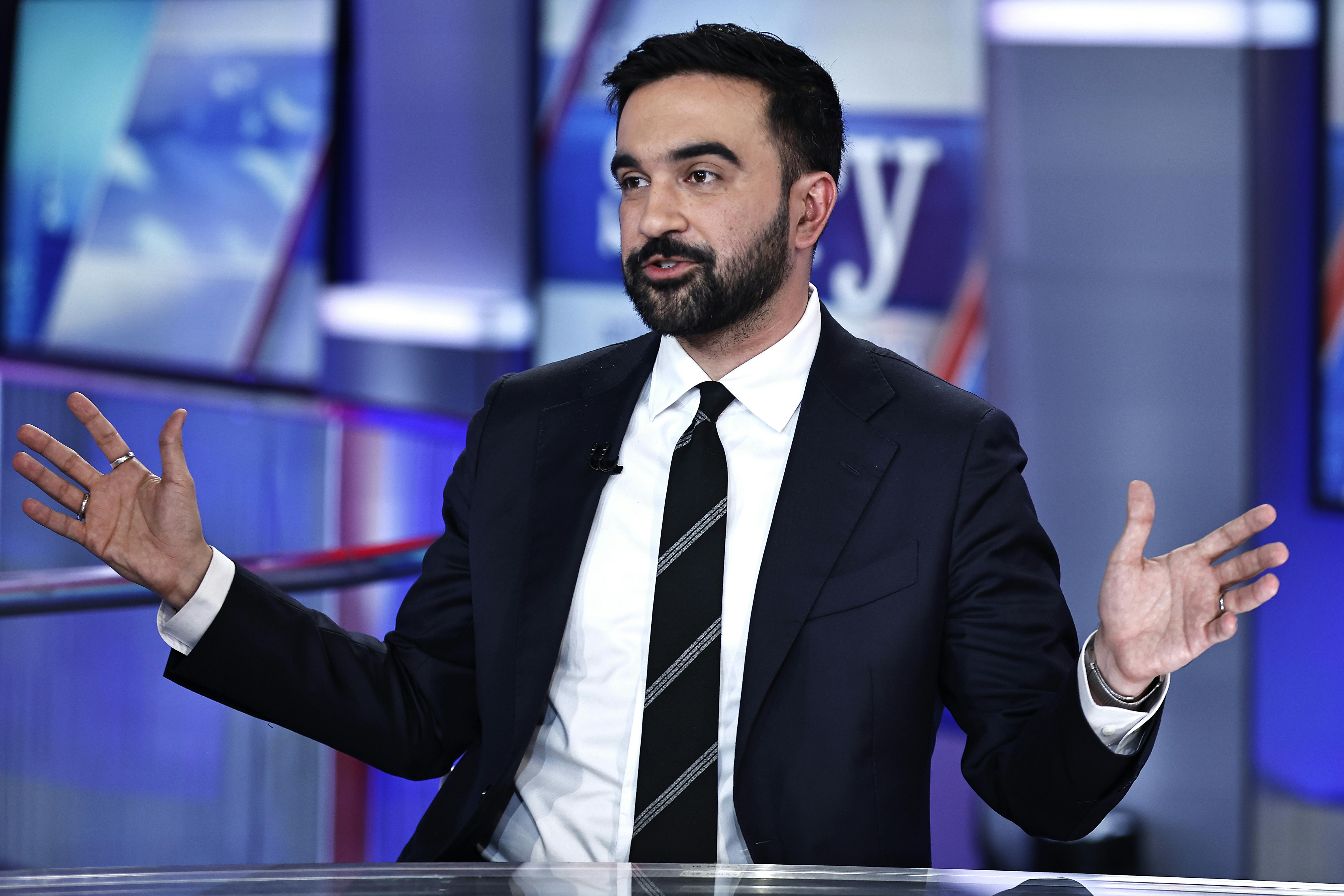 New York City mayoral candidate Zohran Mamdani holds his arms out to the side while speaking