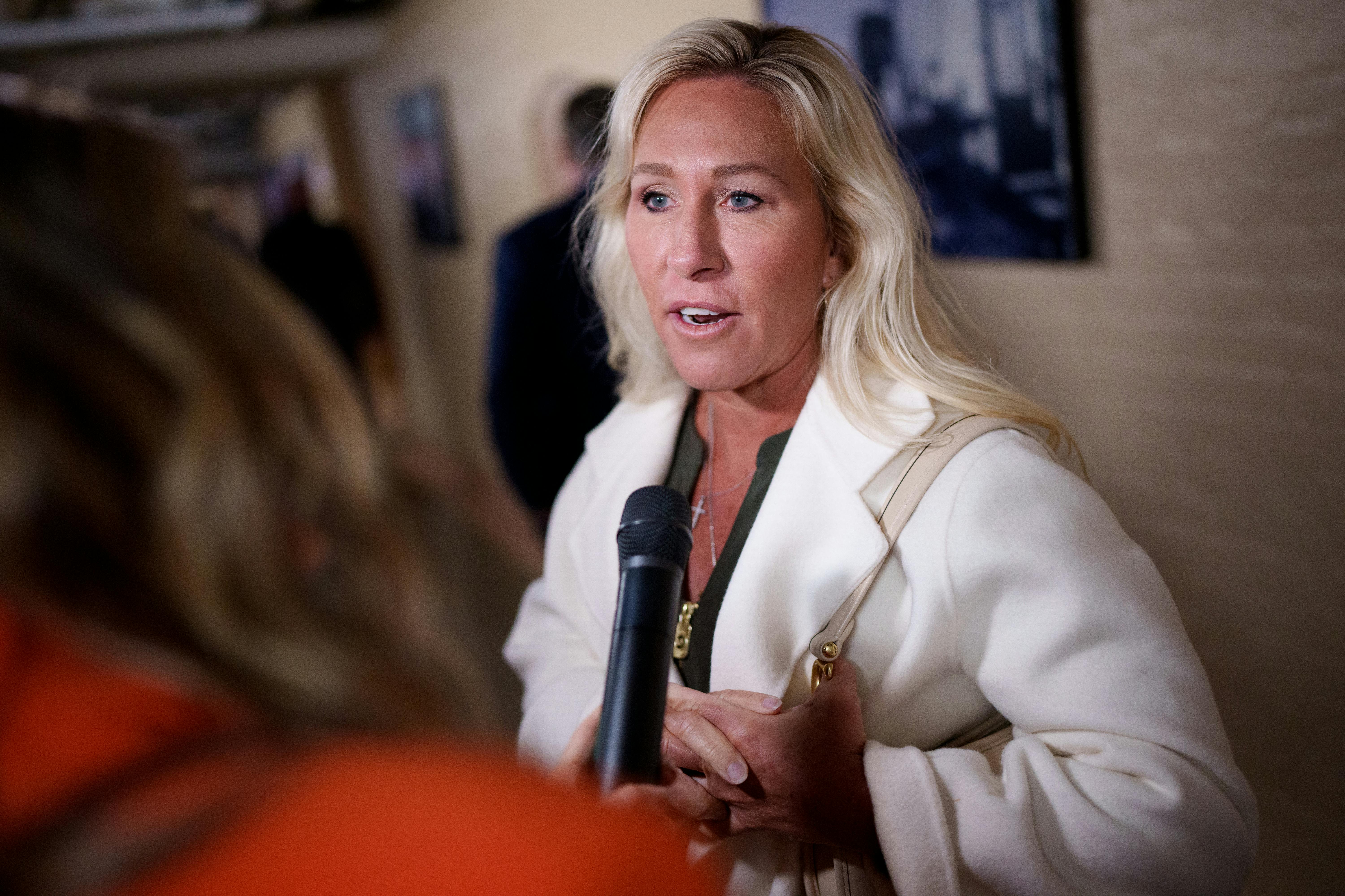 Representative Marjorie Taylor Greene talks to a reporter in the Capitol.