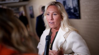 Representative Marjorie Taylor Greene talks to a reporter in the Capitol.