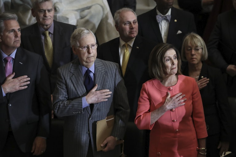 Nancy Pelosi and Mitch McConnell put their hands on their hearts, as other members of Congress do the same around them