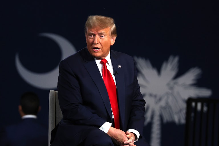 Donald Trump, seated, speaks while looking at someone not on camera