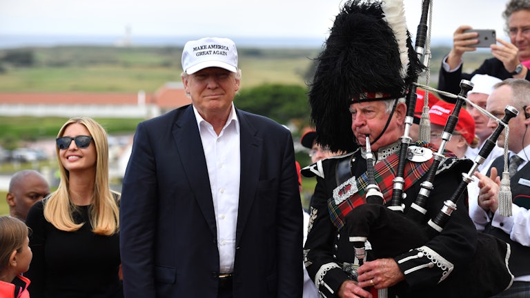 Donald and Ivanka Trump stand beside a bagpiper at the family's gold resort in Scotland.