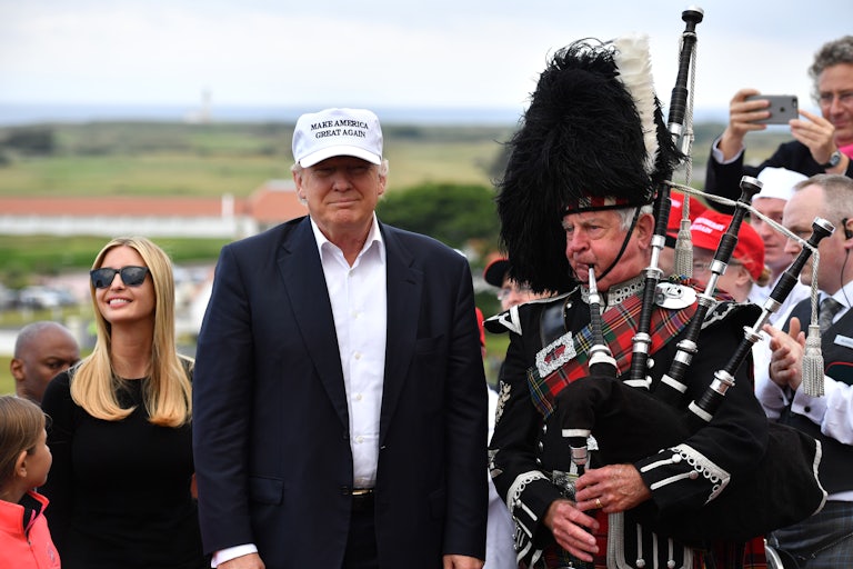 Donald and Ivanka Trump stand beside a bagpiper at the family's gold resort in Scotland.