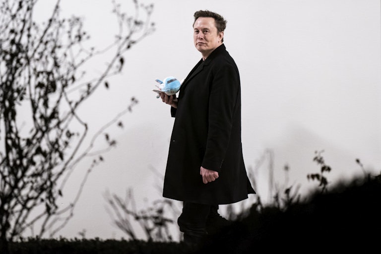 Elon Musk walks outside the White House with an airplane plush toy in his hand.