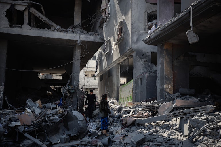 People look through rubble after an Israeli air strike in Gaza City