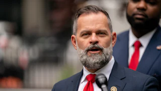 Representative Cory Mills speaks into a microphone