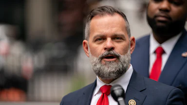 Representative Cory Mills speaks into a microphone