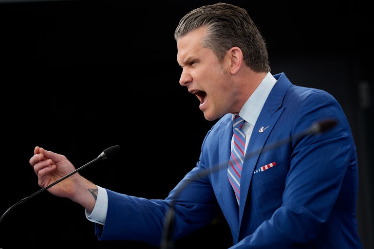 Defense Secretary Pete Hegseth gestures while speaking at a podium