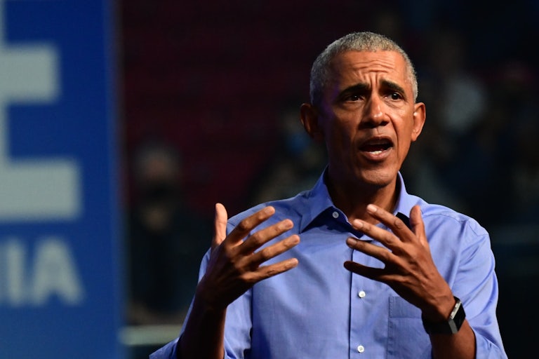 Barack Obama speaks and makes hand gestures, brows furrowed