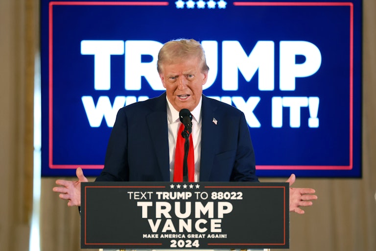 Donald Trump gestures while speaking at a podium