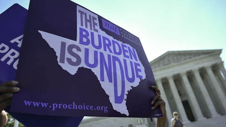 Pro-choice protestors bring signs to the steps of the Supreme Court.