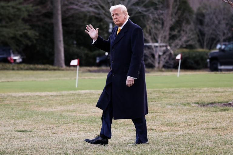 Donald Trump waves while walking outside the White House