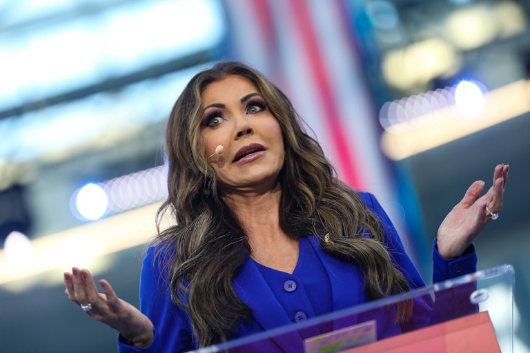 Kristi Noem gestures while speaking at a podium