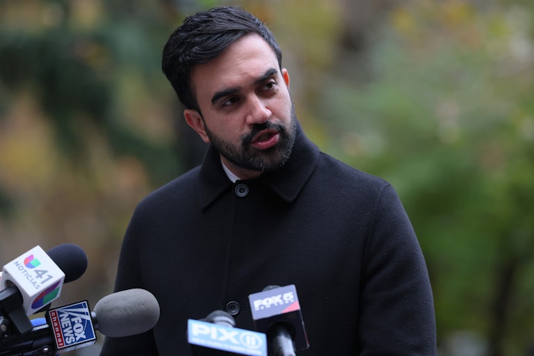 Zohran Mamdani speaks into a microphone at a press conference.