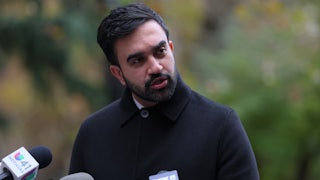 Zohran Mamdani speaks into a microphone at a press conference.