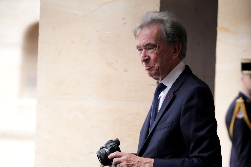 Bernard Arnault, billionaire and chairman of LVMH Moet Hennessy Louis Vuitton SE, photographs his alma mater at a ceremony to mark the funding of a new math research institute at Les Invalides, in Paris, France.