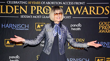 E. Jean Carroll holds her arms out to the side while posing on the red carpet at an event