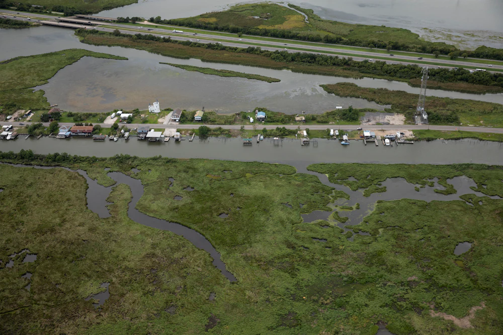 An aerial shot of homes on Ridgeway Boulevard in New Orleans, near Lake Pontchartrain, surrounded by water and marshland.