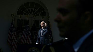 Joseph Biden gives a thumbs up in the darkness as a man blocks a camera.