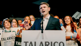 Talarico stands at a podium reading "TALARICO FOR TEXAS," speaking into a microphone as supporters stand behind him.