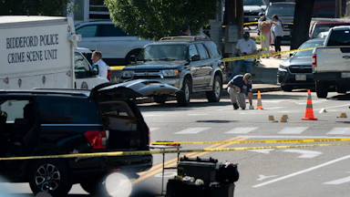 An FBI official places an evidence card on Pool Street in Biddeford where a man was fatally shot by ICE agents, July 13.