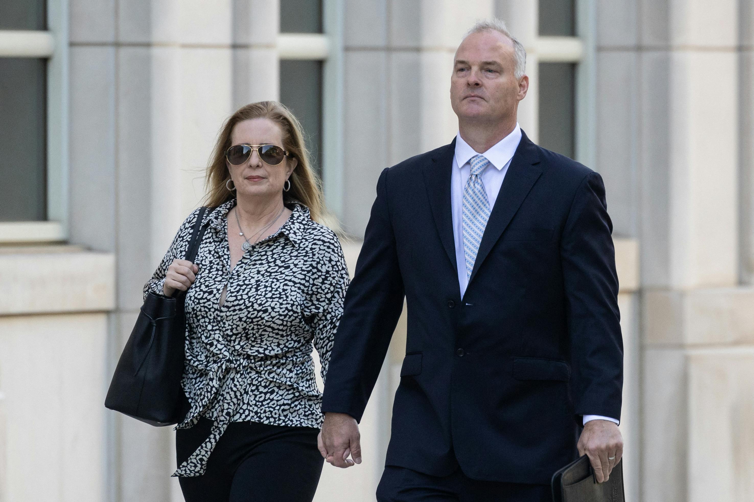 Michael McMahon walks outside court with a woman by his side.