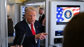 Donald Trump points while speaking to reporters on Air Force One