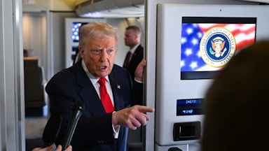 Donald Trump points while speaking to reporters on Air Force One