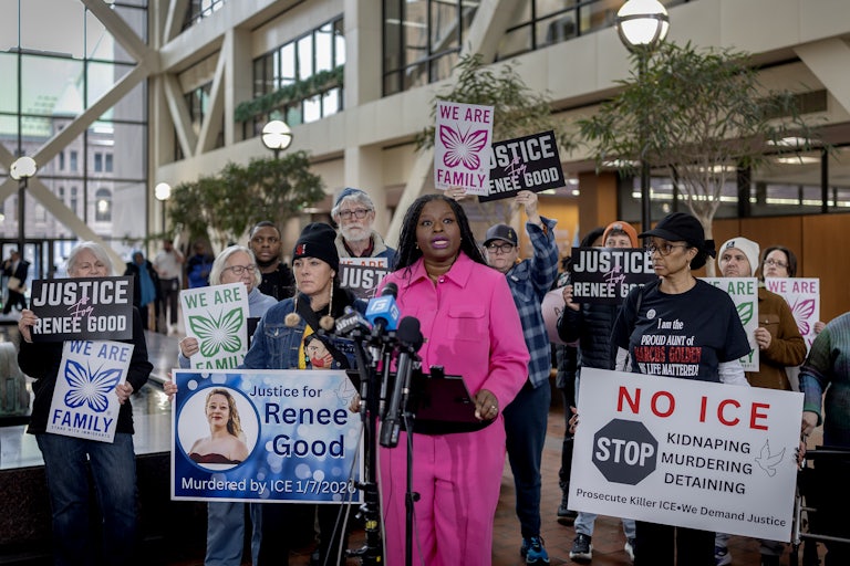Nekima Levy Armstrong speaks during a press conference as others hold signs against ICE and in remembrance of Renee Good.