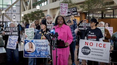 Nekima Levy Armstrong speaksk during a press conference as others hold signs against ICE and in remembrance of Renee Good.