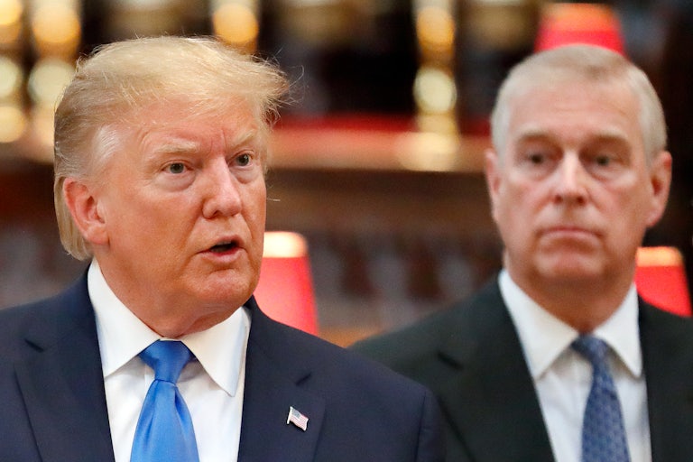 Donald Trump speaks while Prince Andrew stands behind him